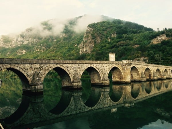 Business Goals is a reflection of last year's performance. Illustrated by and ancient arched bride with mountain in the background and still reflection of bridge in the water in the forefront.