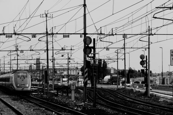 Routines depicted by a train yards wiring, signals, tracks, and train. All in black and white.