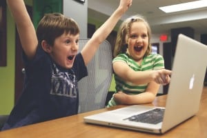 Success and Failure: depicted by two children playing a video game and cheering because they won!