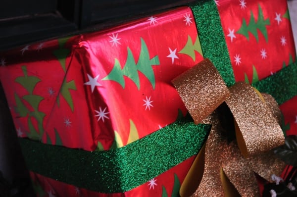 Business Owners Surviving Christmas tip illustrated as a Christmas gift wrapped in Christmas tree paper and glittering green and golden bows.