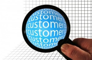 Customer Obsessive illustrated by a magnifying glass being held and magnifying the word customer.